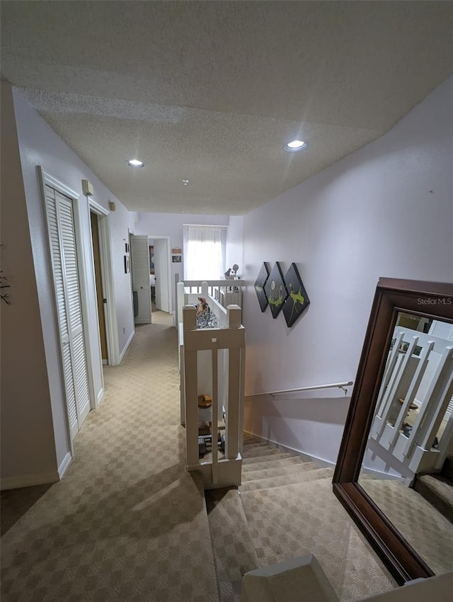 hallway with carpet and a textured ceiling