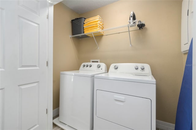 laundry area with washer and clothes dryer and a textured ceiling