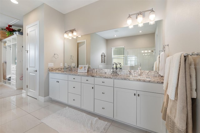 bathroom featuring vanity, a shower with door, and tile patterned floors