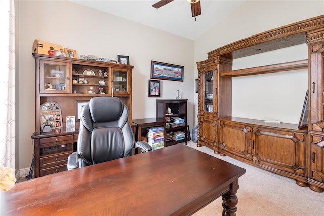 carpeted home office with ceiling fan and vaulted ceiling