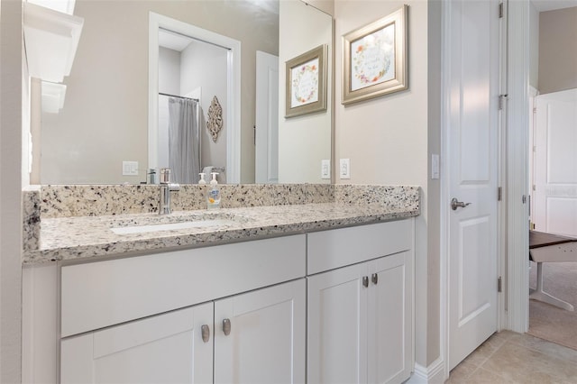 bathroom with walk in shower, vanity, and tile patterned flooring