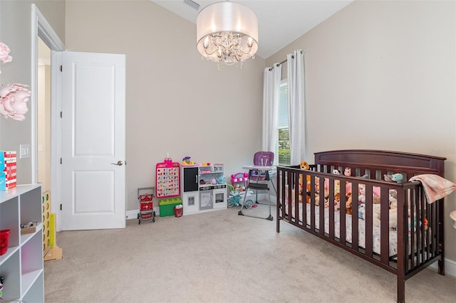 carpeted bedroom featuring a nursery area and an inviting chandelier