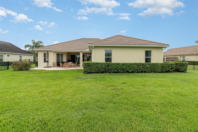 rear view of property featuring a lawn and a patio