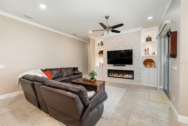 tiled living room with ceiling fan, a fireplace, built in features, and ornamental molding