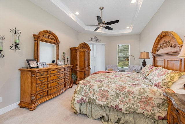 carpeted bedroom with a raised ceiling, ornamental molding, and ceiling fan