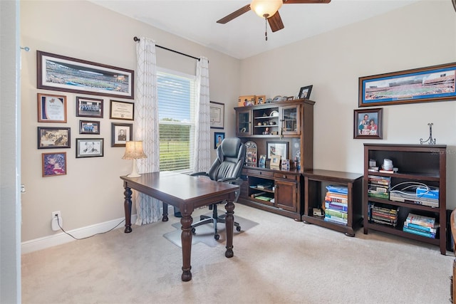 carpeted home office featuring ceiling fan