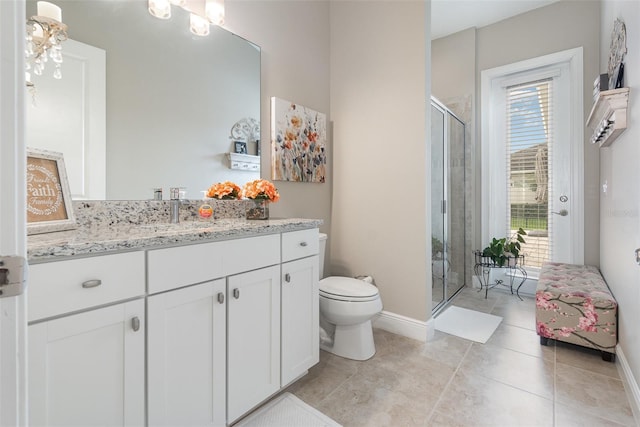 bathroom featuring an enclosed shower, vanity, toilet, and a healthy amount of sunlight