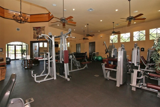 gym with a high ceiling and a chandelier