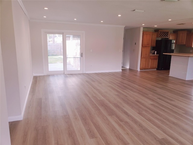 unfurnished living room featuring ornamental molding and light wood-type flooring