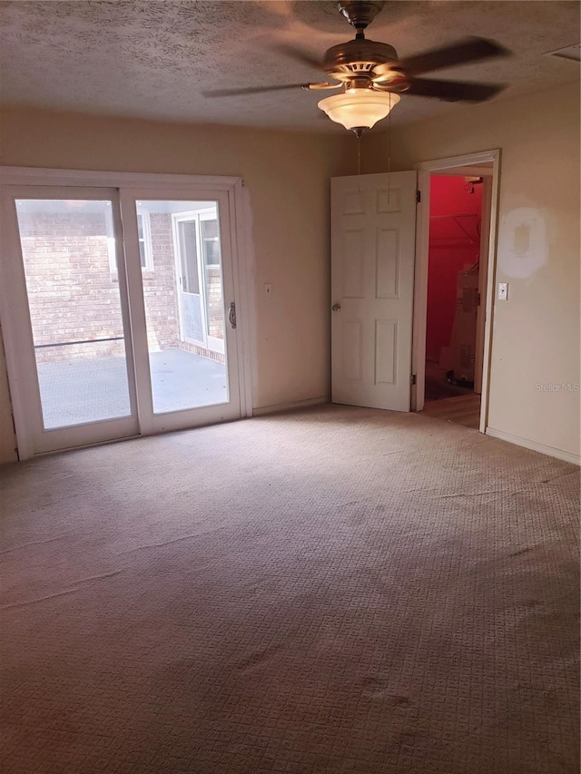 carpeted empty room featuring a textured ceiling and ceiling fan