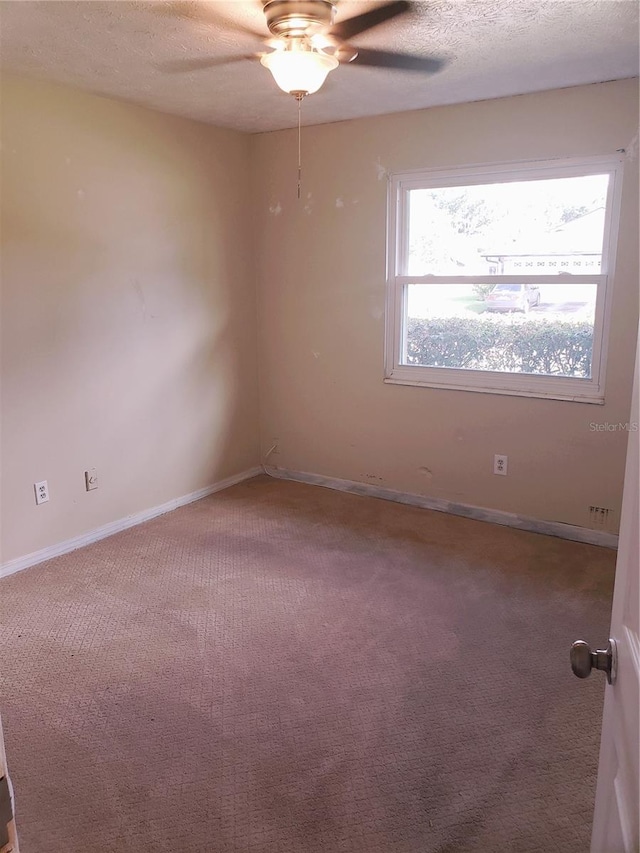 spare room featuring carpet floors, a textured ceiling, and ceiling fan