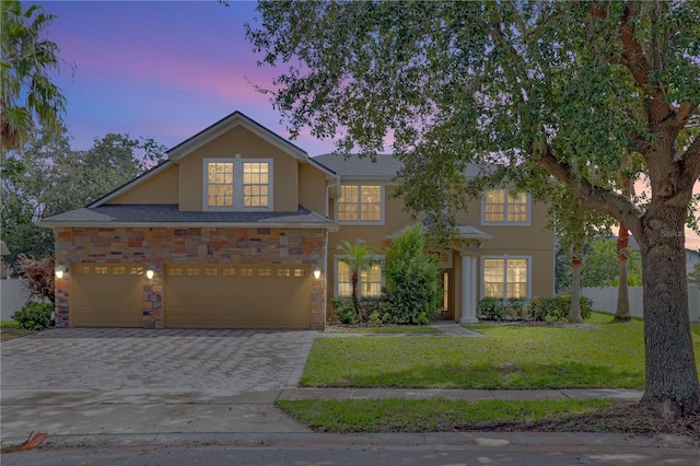 view of front of house featuring a garage and a lawn