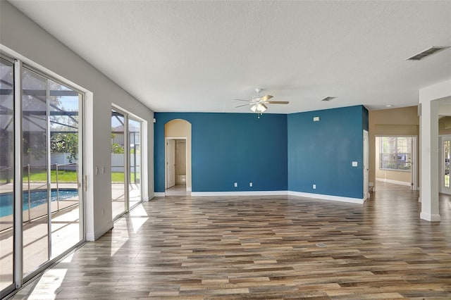 interior space with ceiling fan, a textured ceiling, and dark hardwood / wood-style flooring