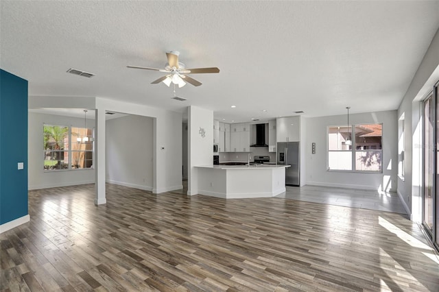 unfurnished living room with dark hardwood / wood-style floors, sink, a textured ceiling, and ceiling fan