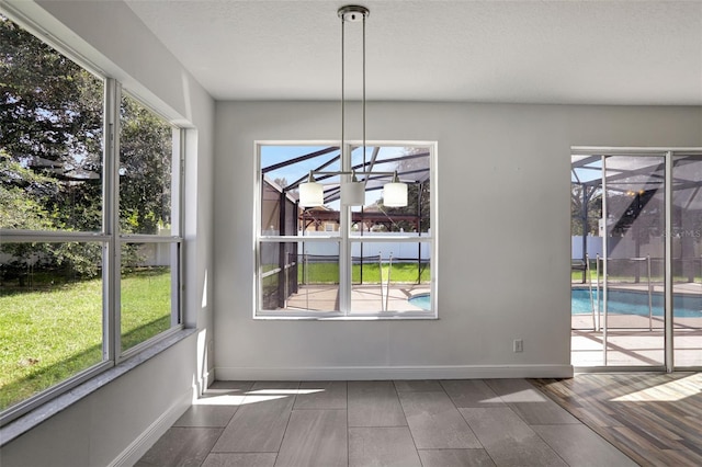 unfurnished dining area featuring a textured ceiling and plenty of natural light