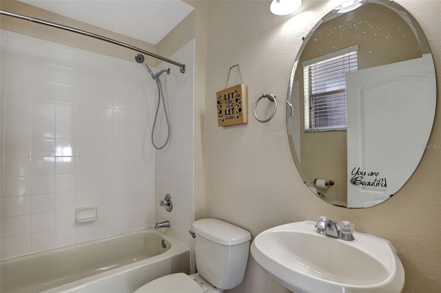 full bathroom with sink, tiled shower / bath combo, and toilet