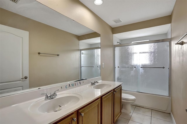 full bathroom featuring tile patterned flooring, combined bath / shower with glass door, vanity, and toilet