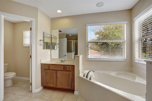 full bathroom featuring vanity, a textured ceiling, tile patterned floors, shower with separate bathtub, and toilet