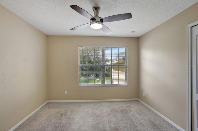 carpeted empty room featuring ceiling fan and a textured ceiling