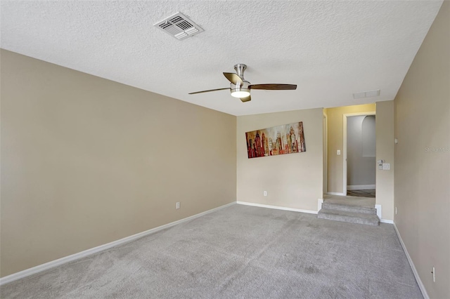 unfurnished room featuring ceiling fan, light colored carpet, and a textured ceiling