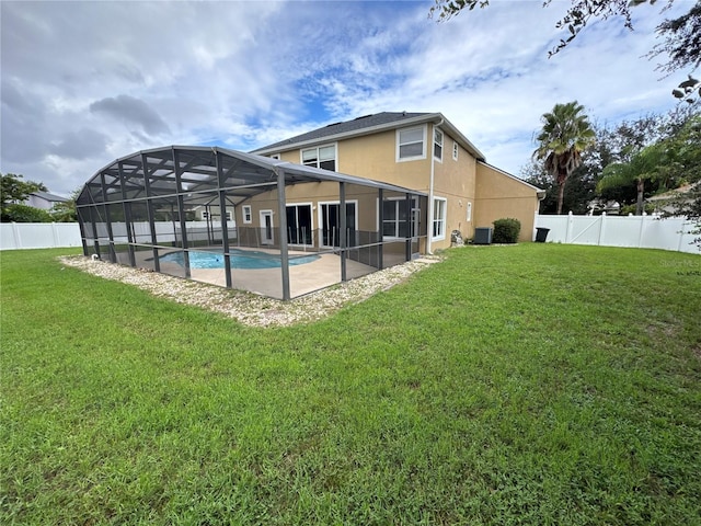 rear view of property with a fenced in pool, a patio, a yard, and a lanai