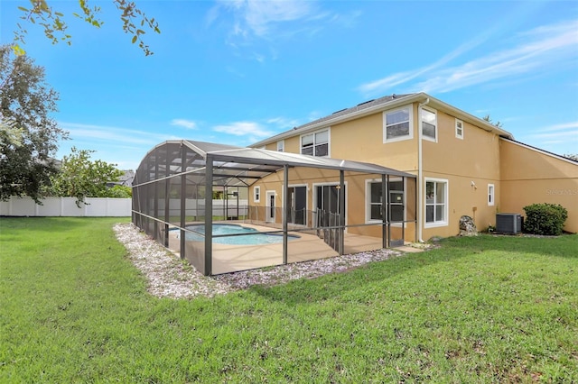 rear view of house featuring a fenced in pool, a patio, a yard, and a lanai