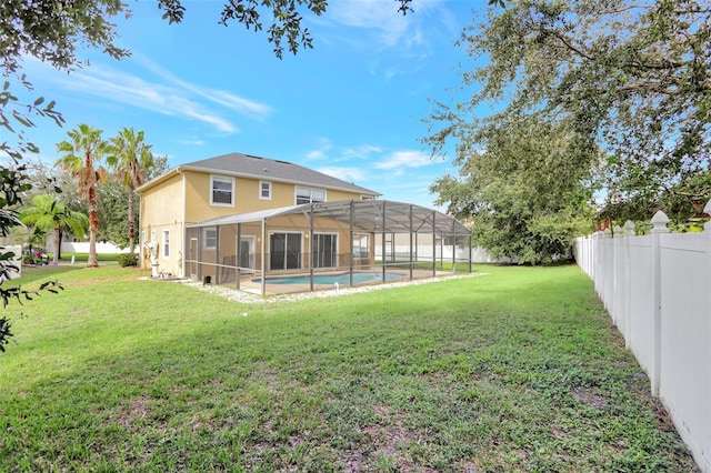 back of house with a yard, glass enclosure, and a fenced in pool