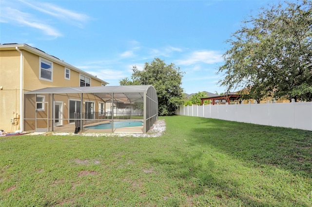 view of yard with a fenced in pool and glass enclosure