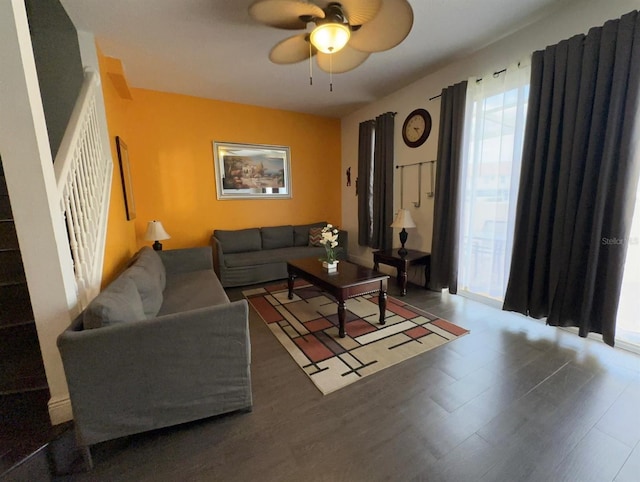 living room featuring ceiling fan and dark wood-type flooring