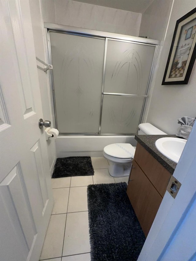 full bathroom with enclosed tub / shower combo, vanity, tile patterned flooring, and toilet