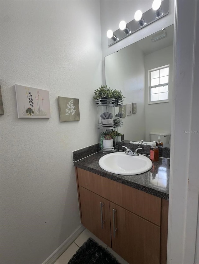 bathroom featuring tile patterned floors, vanity, and toilet