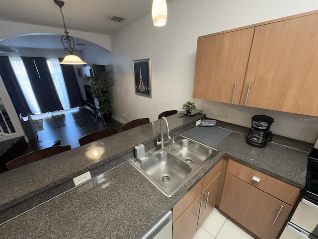 kitchen with hanging light fixtures, kitchen peninsula, sink, and light tile patterned floors