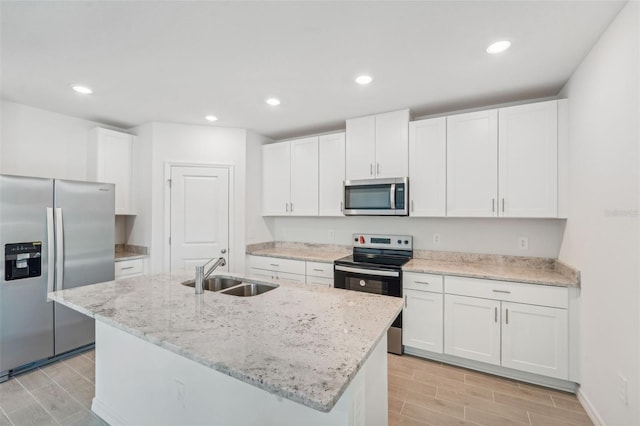 kitchen featuring a center island with sink, sink, white cabinetry, and appliances with stainless steel finishes