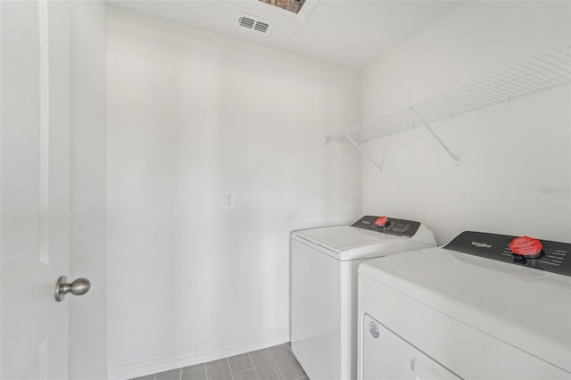 laundry room featuring washer and clothes dryer and light wood-type flooring