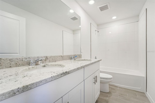 full bathroom with toilet, vanity, and tiled shower / bath