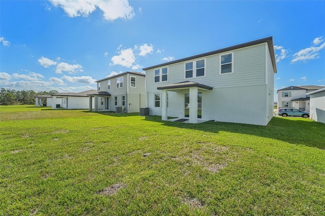 rear view of property featuring central AC and a yard