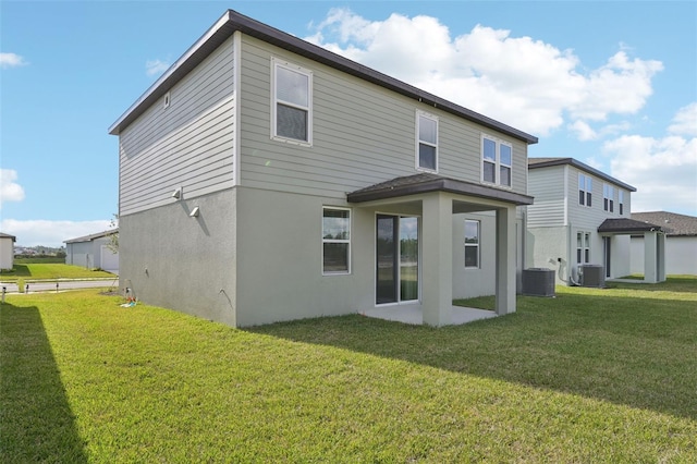 rear view of property featuring central air condition unit and a yard