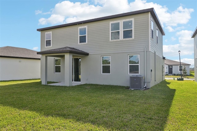 rear view of house featuring a lawn and central air condition unit