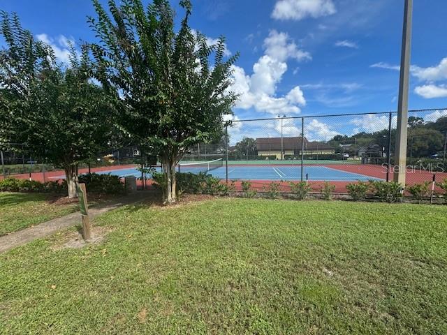 view of swimming pool featuring a yard and tennis court