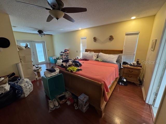 bedroom with access to exterior, a textured ceiling, dark hardwood / wood-style floors, and ceiling fan