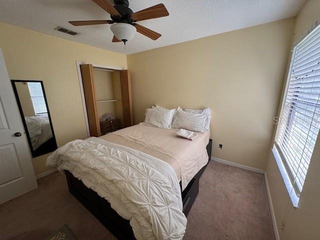 bedroom featuring ceiling fan, carpet floors, and a textured ceiling