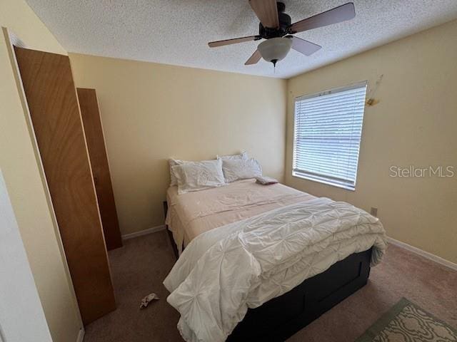 carpeted bedroom with a textured ceiling and ceiling fan