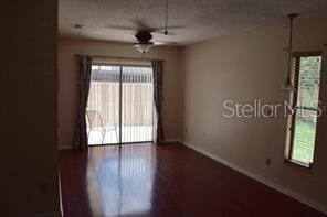 empty room with ceiling fan and dark wood-type flooring