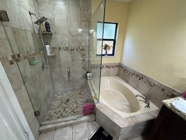 bathroom with separate shower and tub, tile patterned flooring, and vanity