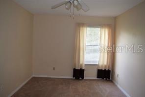 carpeted spare room featuring ceiling fan