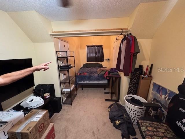 bedroom with light colored carpet and a textured ceiling