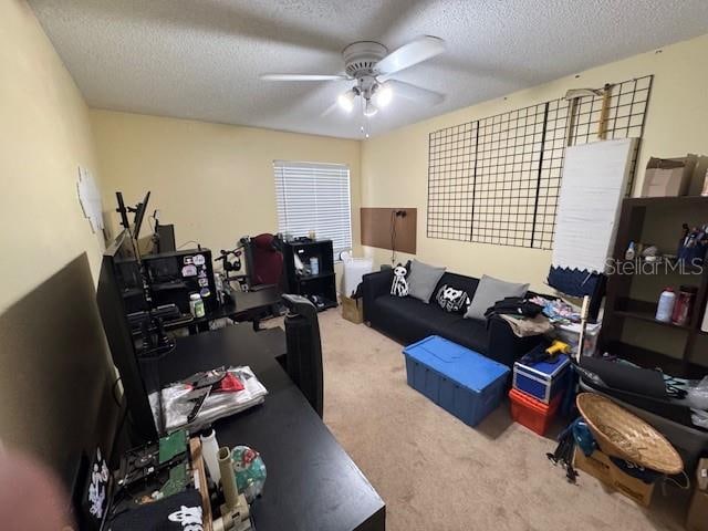 home office featuring carpet, ceiling fan, and a textured ceiling