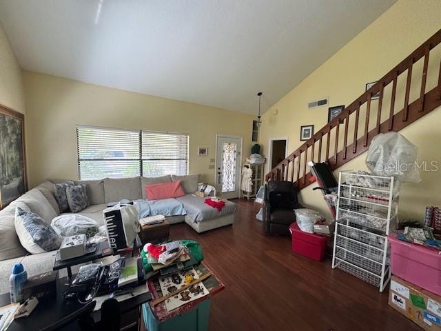 living room with dark hardwood / wood-style flooring and vaulted ceiling