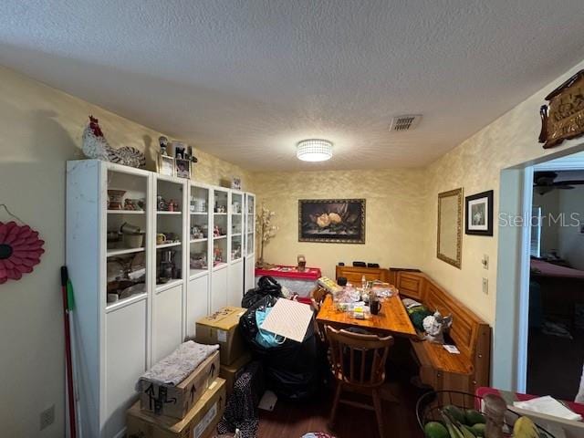 dining area with wood-type flooring and a textured ceiling