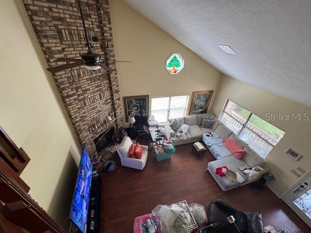 living room with hardwood / wood-style floors, a textured ceiling, high vaulted ceiling, and ceiling fan